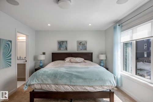 Bedroom featuring a dark wood bed frame, recessed lighting, and a window with roller shades - 14221 101 Avenue Nw, Edmonton, AB - Indoor Photo Showing Bedroom