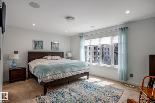 Recessed lighting illuminates this room featuring wall-to-wall carpeting and a large multi-pane window - 14221 101 Avenue Nw, Edmonton, AB - Indoor Photo Showing Bedroom