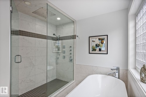 Glass-enclosed shower with full-height marble-look tile, rain shower head, and body sprays - 14221 101 Avenue Nw, Edmonton, AB - Indoor Photo Showing Bathroom