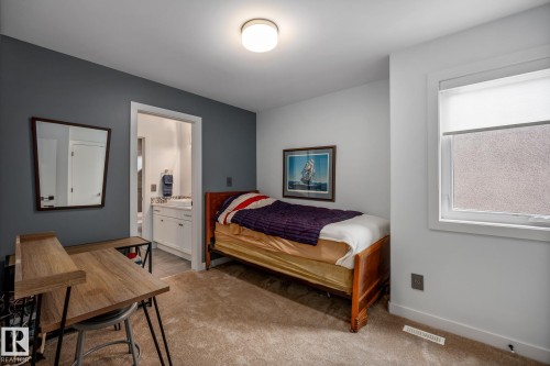 Carpeted room featuring a window with roller shades, a ceiling-mounted light fixture, and a neutral wall color - 14221 101 Avenue Nw, Edmonton, AB - Indoor Photo Showing Bedroom