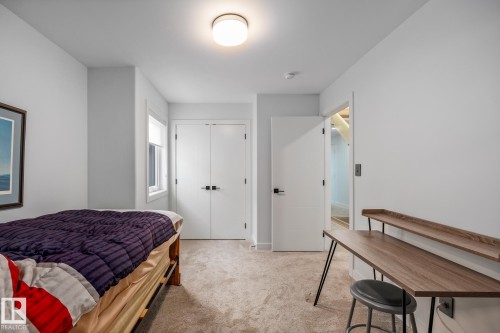Bedroom with neutral carpeting, white walls, and a contemporary flush-mount ceiling light - 14221 101 Avenue Nw, Edmonton, AB - Indoor Photo Showing Bedroom