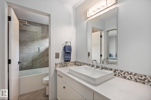 White vanity featuring a vessel sink with chrome fixtures - 14221 101 Avenue Nw, Edmonton, AB - Indoor Photo Showing Bathroom