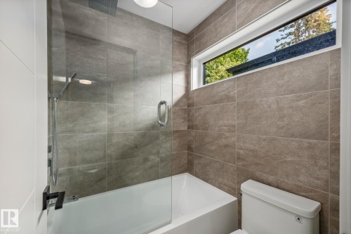 Bathtub with glass shower partition and handheld shower fixture - 14221 101 Avenue Nw, Edmonton, AB - Indoor Photo Showing Bathroom