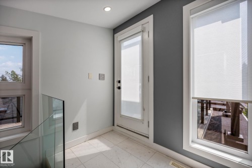 Interior space featuring a frosted glass door, multiple windows with roller shades, recessed lighting, glass railing, and light-toned tile flooring - 14221 101 Avenue Nw, Edmonton, AB - Indoor Photo Showing Other Room