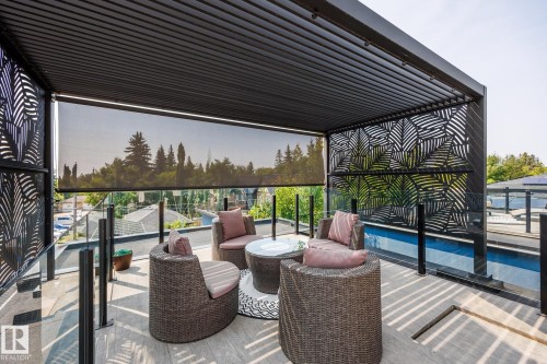 Outdoor covered patio featuring a slatted roof, decorative metal privacy screens, glass railings, and a retractable shade - 14221 101 Avenue Nw, Edmonton, AB - Outdoor With Deck Patio Veranda With Exterior