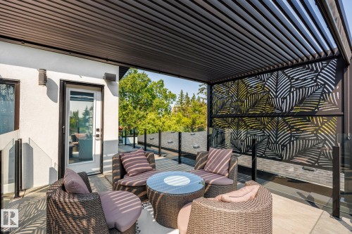 Rooftop patio featuring a slatted pergola, decorative privacy screens, and glass panel railings - 14221 101 Avenue Nw, Edmonton, AB - Outdoor With Deck Patio Veranda