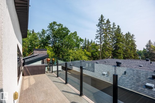 Outdoor balcony featuring wood-finish decking and a glass railing system - 14221 101 Avenue Nw, Edmonton, AB - Outdoor