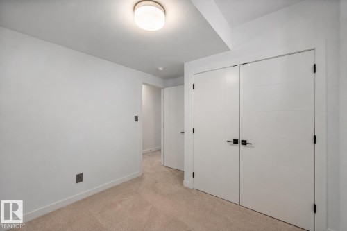 Neutral-toned carpeting extends throughout this room, complemented by white walls and trim - 14221 101 Avenue Nw, Edmonton, AB - Indoor Photo Showing Other Room