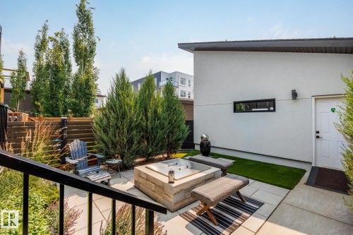 Private outdoor patio featuring a built-in spa, paver stone hardscaping, lush perimeter landscaping, and a secure privacy fence - 14221 101 Avenue Nw, Edmonton, AB - Outdoor With Exterior