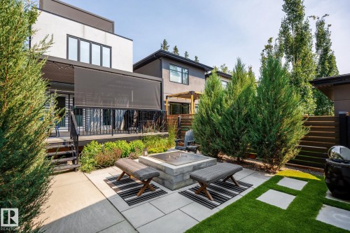Modern backyard featuring a built-in fire pit, artificial turf, and rectangular paver patio - 14221 101 Avenue Nw, Edmonton, AB - Outdoor With Deck Patio Veranda With Exterior