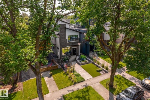Modern architectural exterior featuring a prominent stone facade, large black-framed windows, and a flat roofline - 14221 101 Avenue Nw, Edmonton, AB - Outdoor