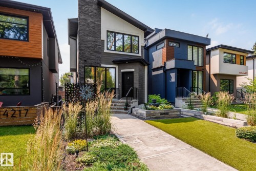 Modern facade featuring a stone-clad chimney and contrasting siding materials - 14221 101 Avenue Nw, Edmonton, AB - Outdoor