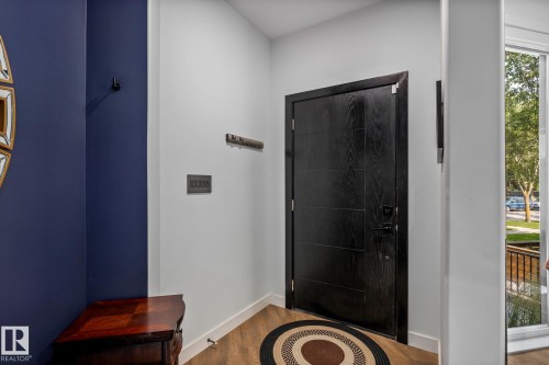 Modern entry door with dark wood-finish paneling, contemporary handle set, and dark trim - 14221 101 Avenue Nw, Edmonton, AB - Indoor Photo Showing Other Room