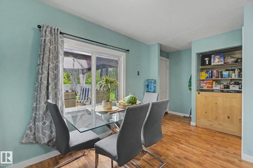 Interior space featuring wood-finish flooring, light blue wall paint, and a sliding glass door providing exterior access - 18407 95A Avenue Nw, Edmonton, AB - Indoor Photo Showing Dining Room