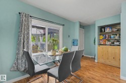 Interior space featuring wood-finish flooring, light blue wall paint, and a sliding glass door providing exterior access - 