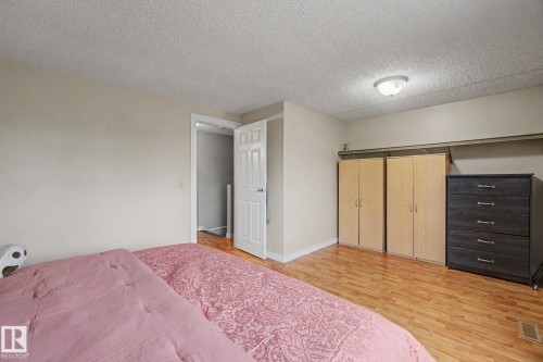 Room featuring wood-finish flooring, neutral wall tones, and a ceiling-mounted light fixture - 18407 95A Avenue Nw, Edmonton, AB - Indoor Photo Showing Bedroom