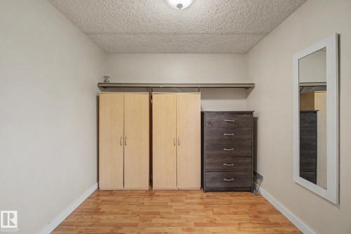Room featuring wood-finish flooring, light-colored walls, and a textured ceiling - 18407 95A Avenue Nw, Edmonton, AB - Indoor Photo Showing Other Room