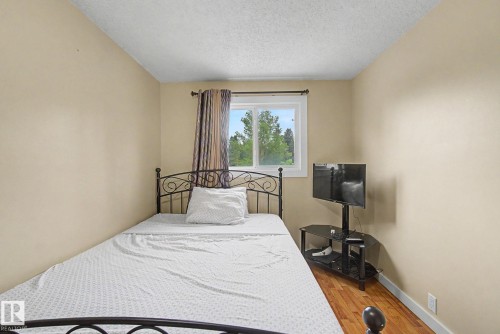 Room featuring neutral wall paint, wood-finish flooring, and a single window with a white frame and curtain rod - 18407 95A Avenue Nw, Edmonton, AB - Indoor Photo Showing Bedroom