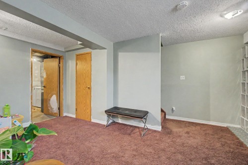 Carpeted room featuring two wood-finish doors and a ceiling-mounted light fixture - 18407 95A Avenue Nw, Edmonton, AB - Indoor