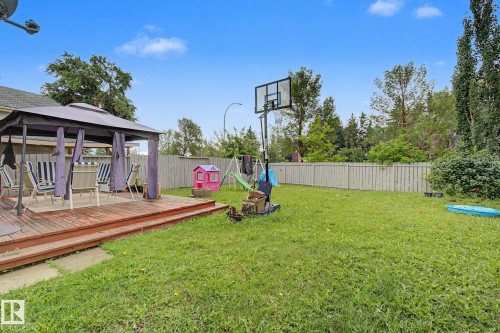 Expansive backyard featuring a multi-level wooden deck with a covered gazebo, a large grassy area, privacy fencing, and mature perimeter foliage - 18407 95A Avenue Nw, Edmonton, AB - Outdoor With Deck Patio Veranda