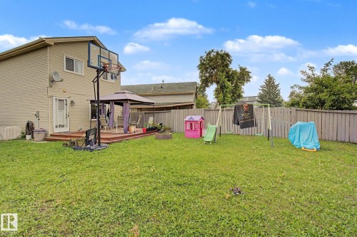 Spacious rear yard with a wooden privacy fence, expansive lawn area, and a raised wooden deck - 18407 95A Avenue Nw, Edmonton, AB - Outdoor With Deck Patio Veranda