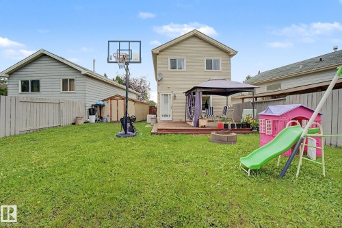 Expansive backyard featuring a green lawn, wood deck, and a gazebo structure - 18407 95A Avenue Nw, Edmonton, AB - Outdoor With Deck Patio Veranda
