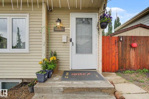 Exterior entry featuring horizontal siding, a white screen door, and a concrete stoop - 18407 95A Avenue Nw, Edmonton, AB - Outdoor With Exterior