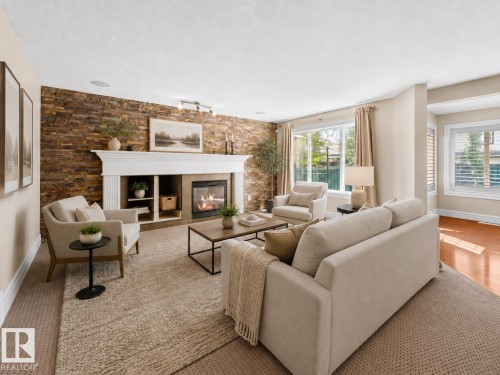 Living area featuring a stone accent wall, white mantel fireplace with built-in shelving, large windows with white trim, recessed lighting, and carpeting - 1338 Rutherford Road Sw, Edmonton, AB - Indoor Photo Showing Living Room With Fireplace