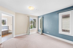 Carpeted room featuring multiple windows with white trim, a semi-flush mount ceiling light, and a two-tone wall treatment - 