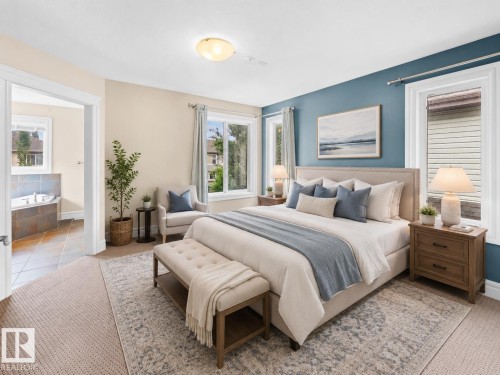 Spacious bedroom featuring carpeted flooring, a recessed ceiling light, and a dedicated doorway opening to an adjacent room with a built-in tub - 1338 Rutherford Road Sw, Edmonton, AB - Indoor Photo Showing Bedroom