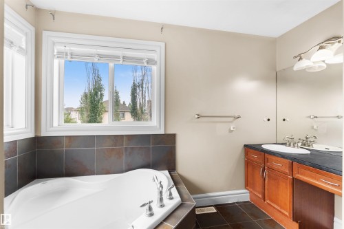 Soaking tub with tiled surround and chrome fixtures - 1338 Rutherford Road Sw, Edmonton, AB - Indoor Photo Showing Bathroom