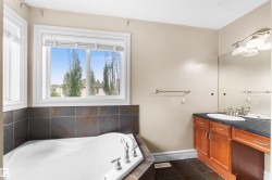 Soaking tub with tiled surround and chrome fixtures - 