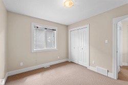 Room featuring neutral wall tones, white trim, and light beige carpeting - 