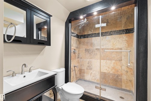 Bathroom featuring a dark wood vanity with white rectangular sink, brushed nickel faucet, and coordinating mirrored medicine cabinet - 1338 Rutherford Road Sw, Edmonton, AB - Indoor Photo Showing Bathroom