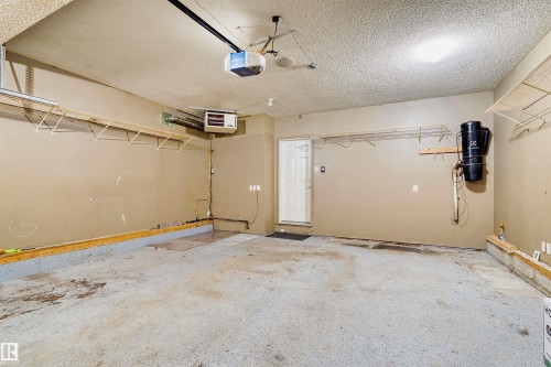 Spacious garage featuring concrete flooring, textured ceiling, and painted walls - 1338 Rutherford Road Sw, Edmonton, AB - Indoor Photo Showing Garage