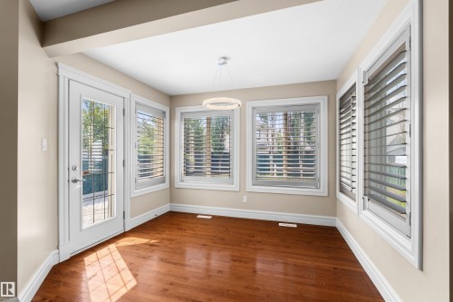 Hardwood flooring beneath a contemporary chandelier - 1338 Rutherford Road Sw, Edmonton, AB - Indoor Photo Showing Other Room