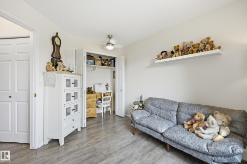 Room featuring wood-finish flooring, a ceiling fan, and a built-in desk area within a closet - #208 9760 176 St Nw, Edmonton, AB - Indoor Photo Showing Other Room
