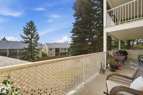 Upper-level balcony featuring a lattice railing, overhead coverage, and a paved surface - #208 9760 176 St Nw, Edmonton, AB - Outdoor With Balcony