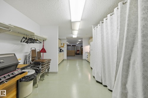 Long hall featuring light-colored flooring, recessed lighting, and a curtained wall - #208 9760 176 St Nw, Edmonton, AB - Indoor Photo Showing Other Room