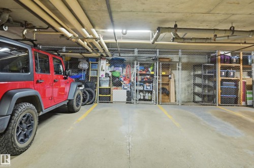 Paved parking space with exposed concrete ceiling and overhead utility piping - #208 9760 176 St Nw, Edmonton, AB - Indoor Photo Showing Garage