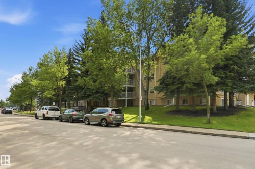 Multi-story residential building with light-colored exterior siding, featuring multiple private balconies - #208 9760 176 St Nw, Edmonton, AB - Outdoor