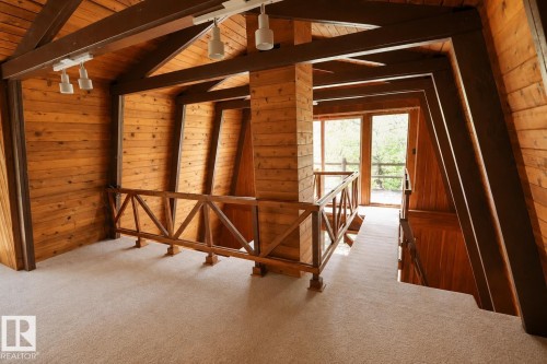 Carpeted loft space featuring natural wood plank walls and ceiling, exposed structural beams, and track lighting - 329 60417 Range Road 124, Rural St. Paul County, AB - Indoor Photo Showing Other Room