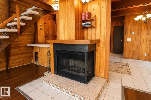 Central fireplace with a tile hearth and wood mantel - 329 60417 Range Road 124, Rural St. Paul County, AB - Indoor Photo Showing Living Room With Fireplace