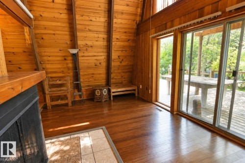 Interior with wood-finish flooring and extensive wood paneling - 329 60417 Range Road 124, Rural St. Paul County, AB - Indoor Photo Showing Other Room With Fireplace