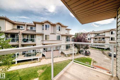 Private balcony with glass railing system overlooking established residential buildings - #72 2505 42 St Nw, Edmonton, AB - Outdoor