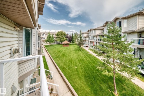 Expansive communal green space featuring a manicured lawn, established trees, and a central gazebo - #72 2505 42 St Nw, Edmonton, AB - Outdoor