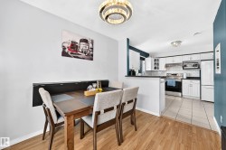 Dining area featuring wood-finish flooring and a contemporary chandelier - 