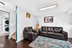 Dark wood-finish flooring complements light-colored walls in this space featuring a built-in overhead light fixture - 