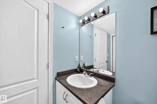 Bathroom vanity featuring a white ceramic sink, dark speckled countertop, and chrome faucet - #72 2505 42 St Nw, Edmonton, AB - Indoor Photo Showing Bathroom