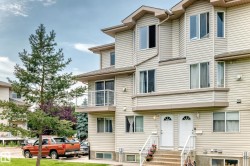 Multi-level exterior featuring light-toned horizontal siding, bay windows, and individual entryways - 